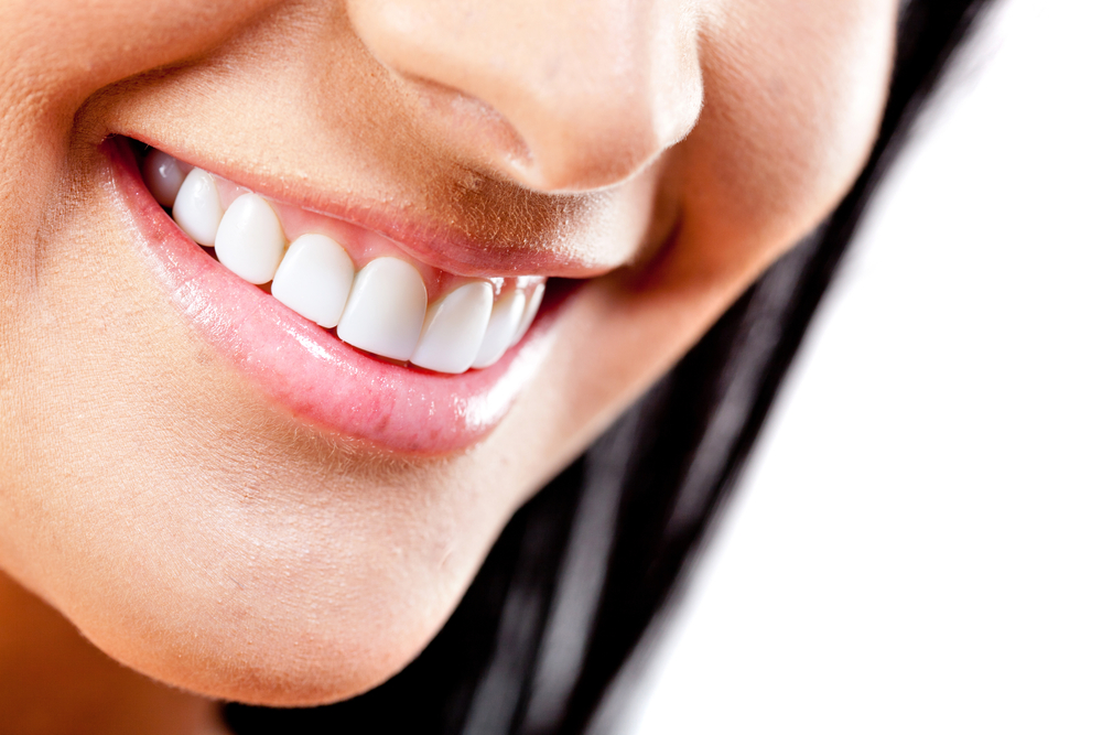 Close-up to beautiful female smile - isolated over a white background